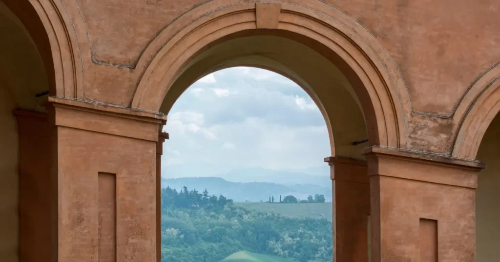 Estructura arquitectónica con un arco abierto de piedra hacia la naturaleza, simbolizando la flexibilidad y una vida con espacio