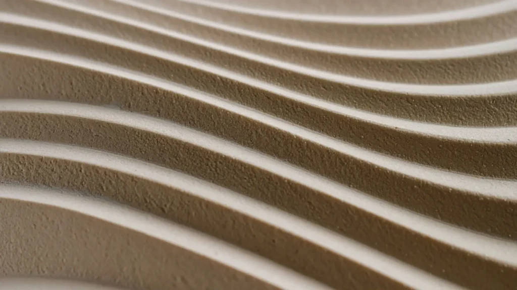 Textura abstracta y minimalista de líneas de arena fina en tonos grises y beige con sombras suaves