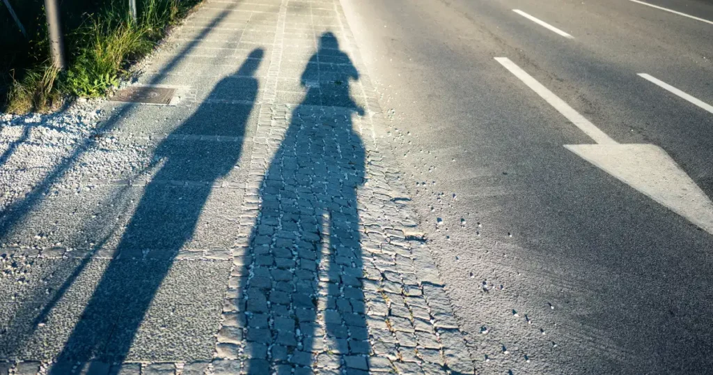 Sombras de dos personas caminando en la misma dirección, representando cercanía, apoyo y respeto por el proceso del otro.