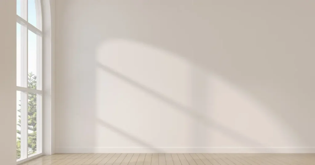 Sombra suave de una ventana sobre una pared clara, representando la tensión silenciosa de aparentar estar bien