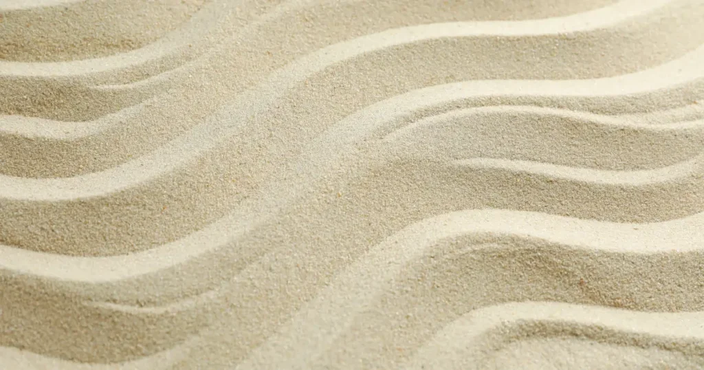 Textura de arena con líneas suaves, evocando el paso del tiempo y el proceso gradual de formación de hábitos