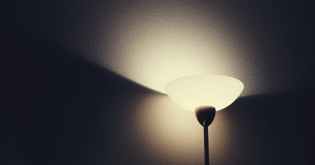 Lámpara encendida en una habitación oscura, representando la exposición a luz artificial durante la noche